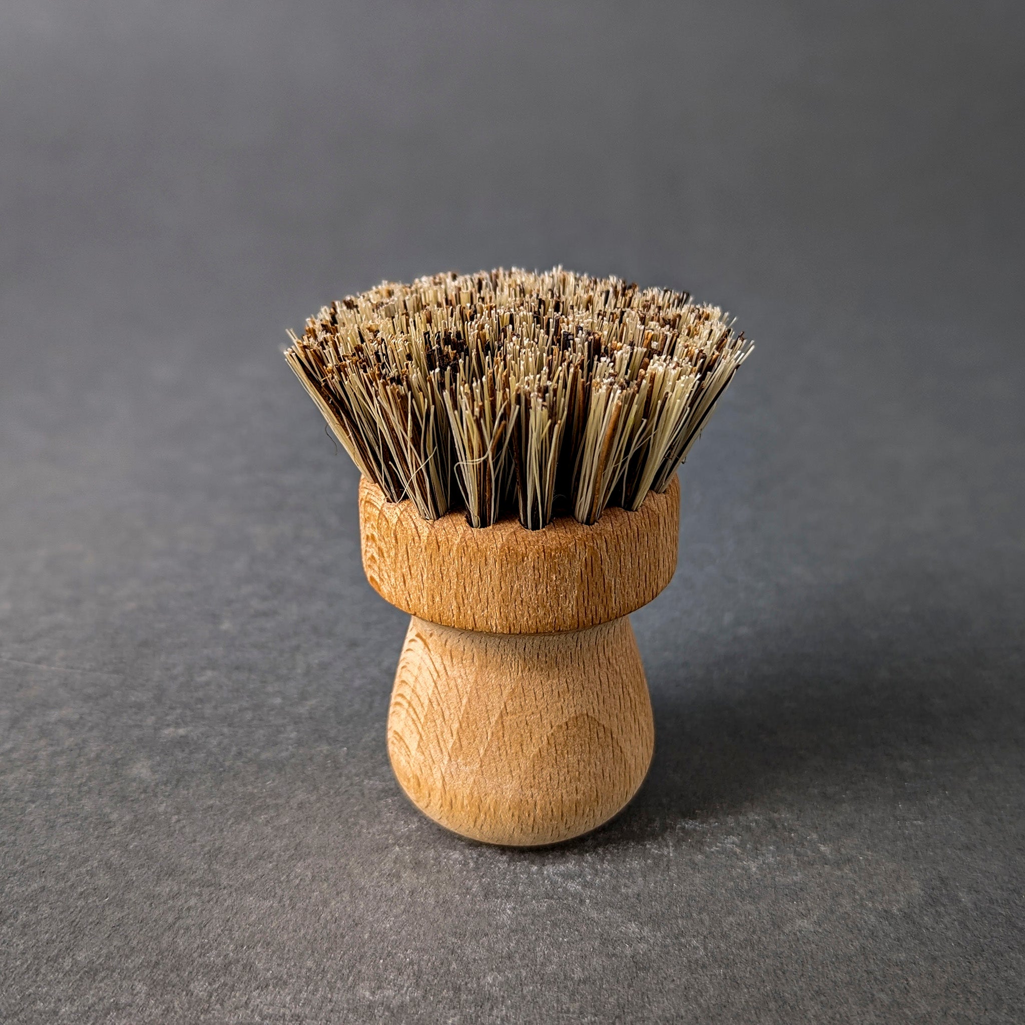 bristled pot and pan brush with wooden handle standing upward