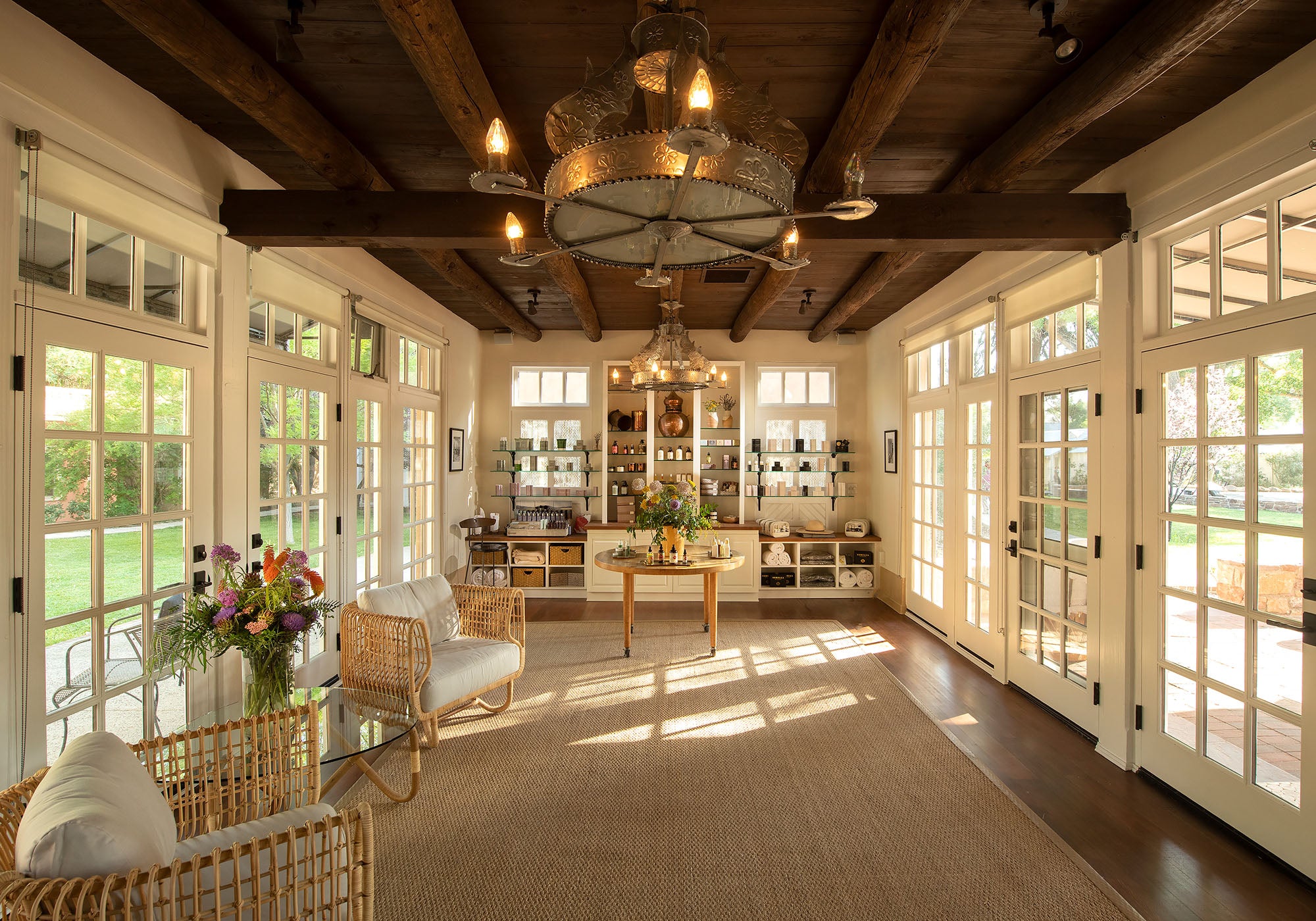 spa reception with wooden beams, large windows, and a chandelier.