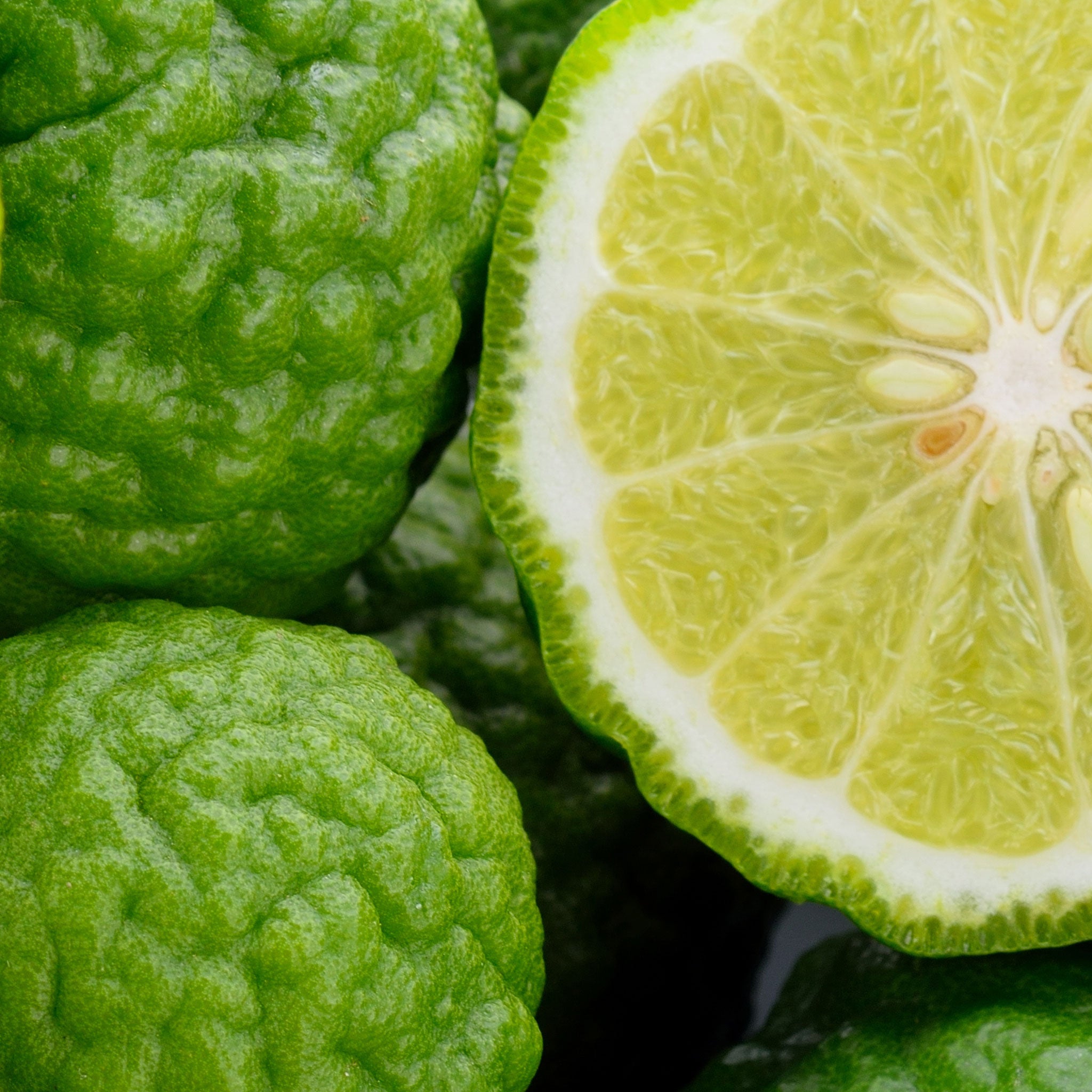 Green fruit bergamot, with a close-up of a halved one showing its interior.