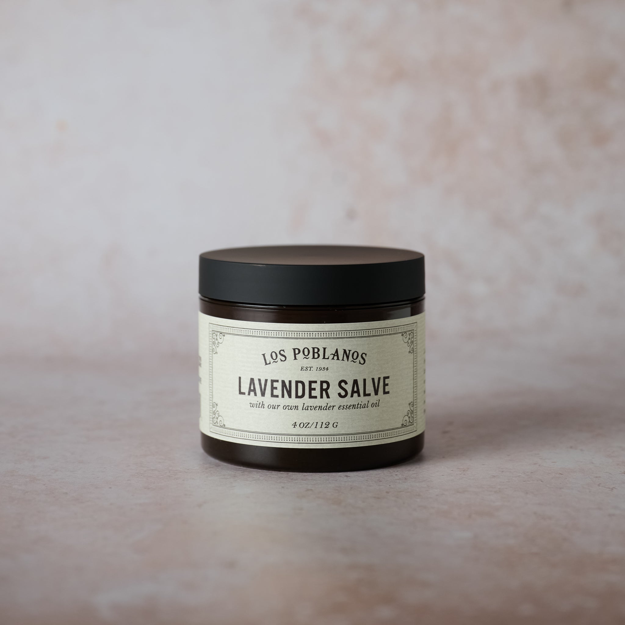 A 4 oz amber plastic jar of Los Poblanos Lavender Salve with a label that includes the product name and the fact that it is made with organic lavender.