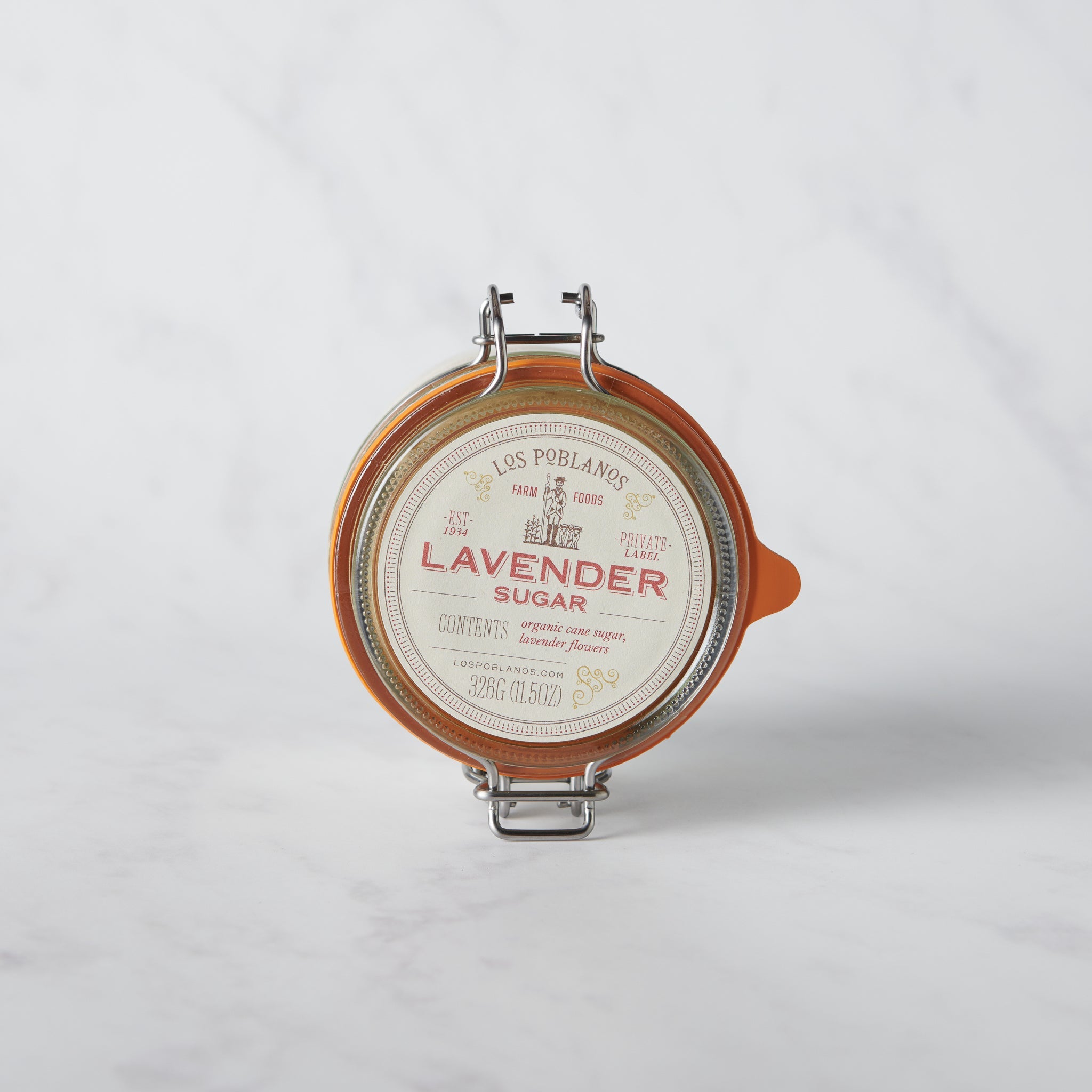 A reusable glass jar with a metal clasp lid labeled 'LAVENDER SUGAR' containing pink lavender sugar.