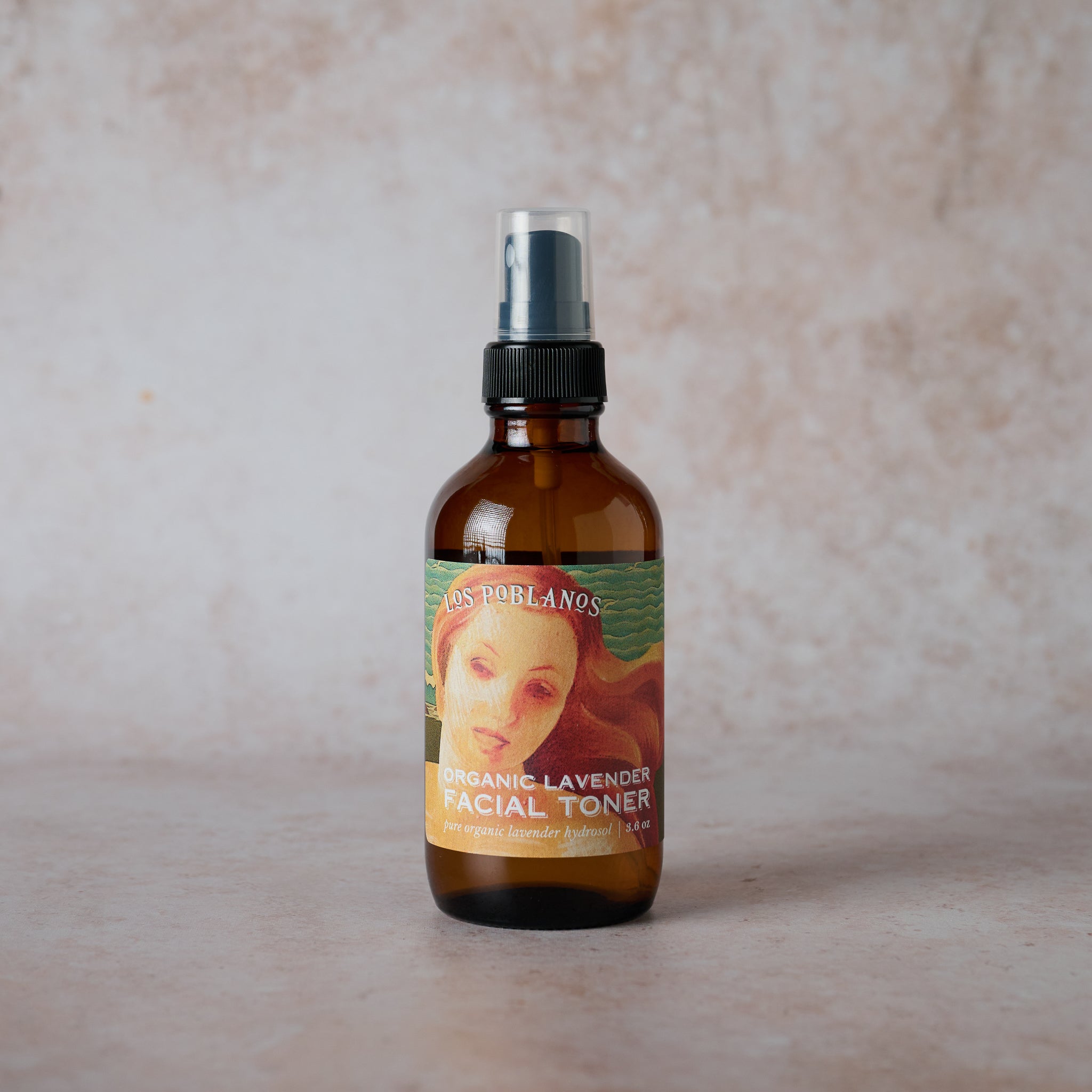 A glass spray bottle labeled 'Organic Lavender Facial Toner', with a label featuring a vintage illustration of a woman.