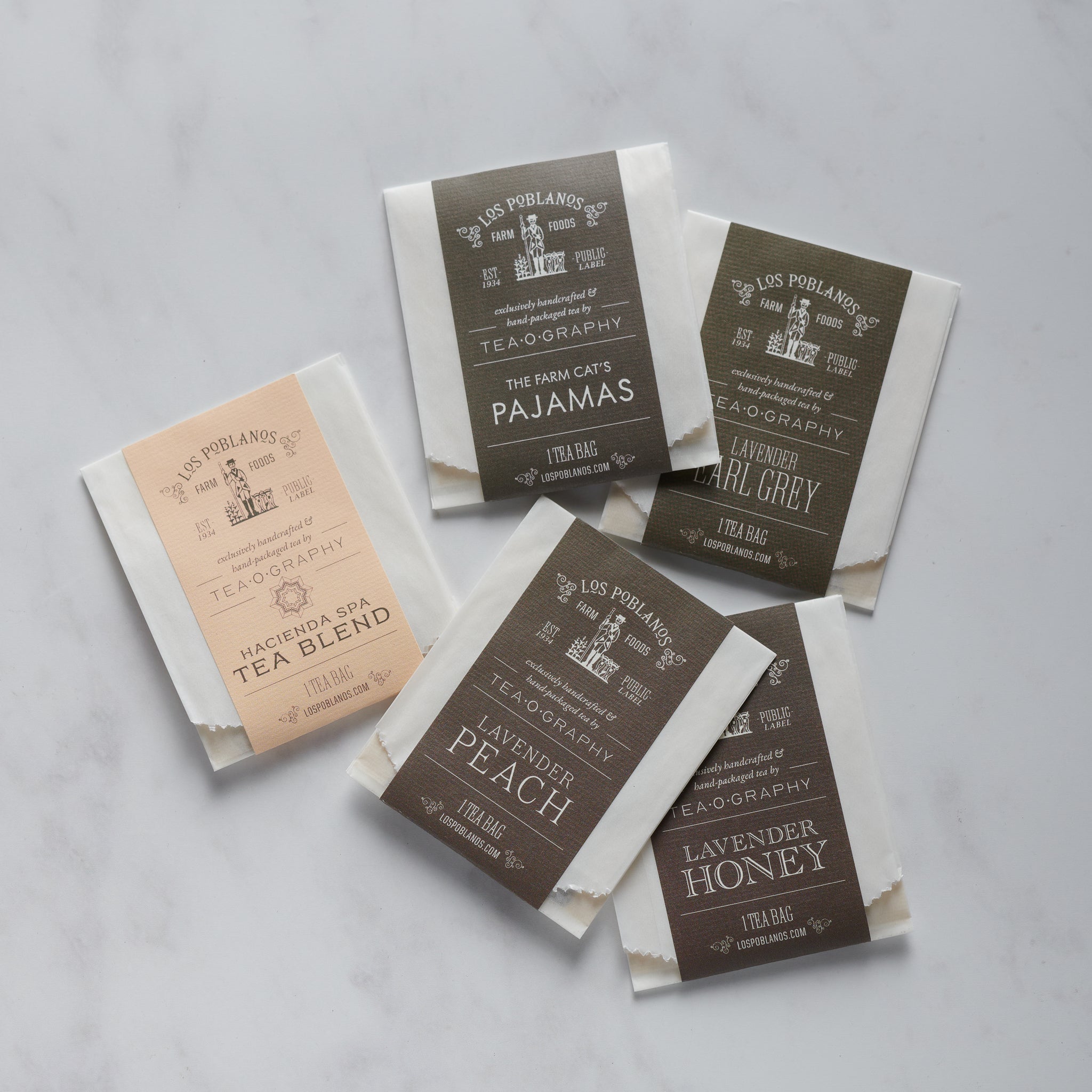 Five individual tea bags with labels showing different tea names and flavors such as Lavender Peach, Lavender Honey, and Lavender Earl Grey.