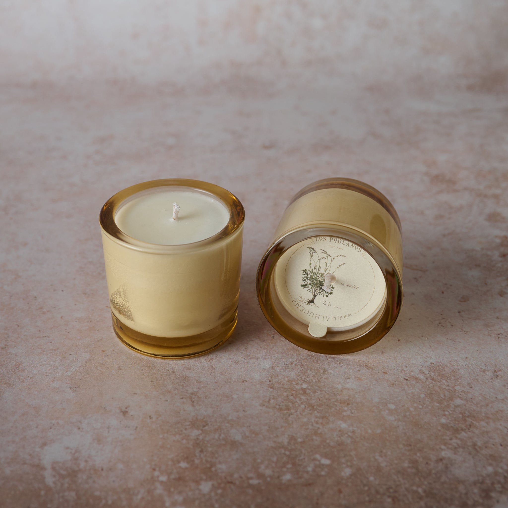 A soy wax candle in an amber glass jar . The candle is white.