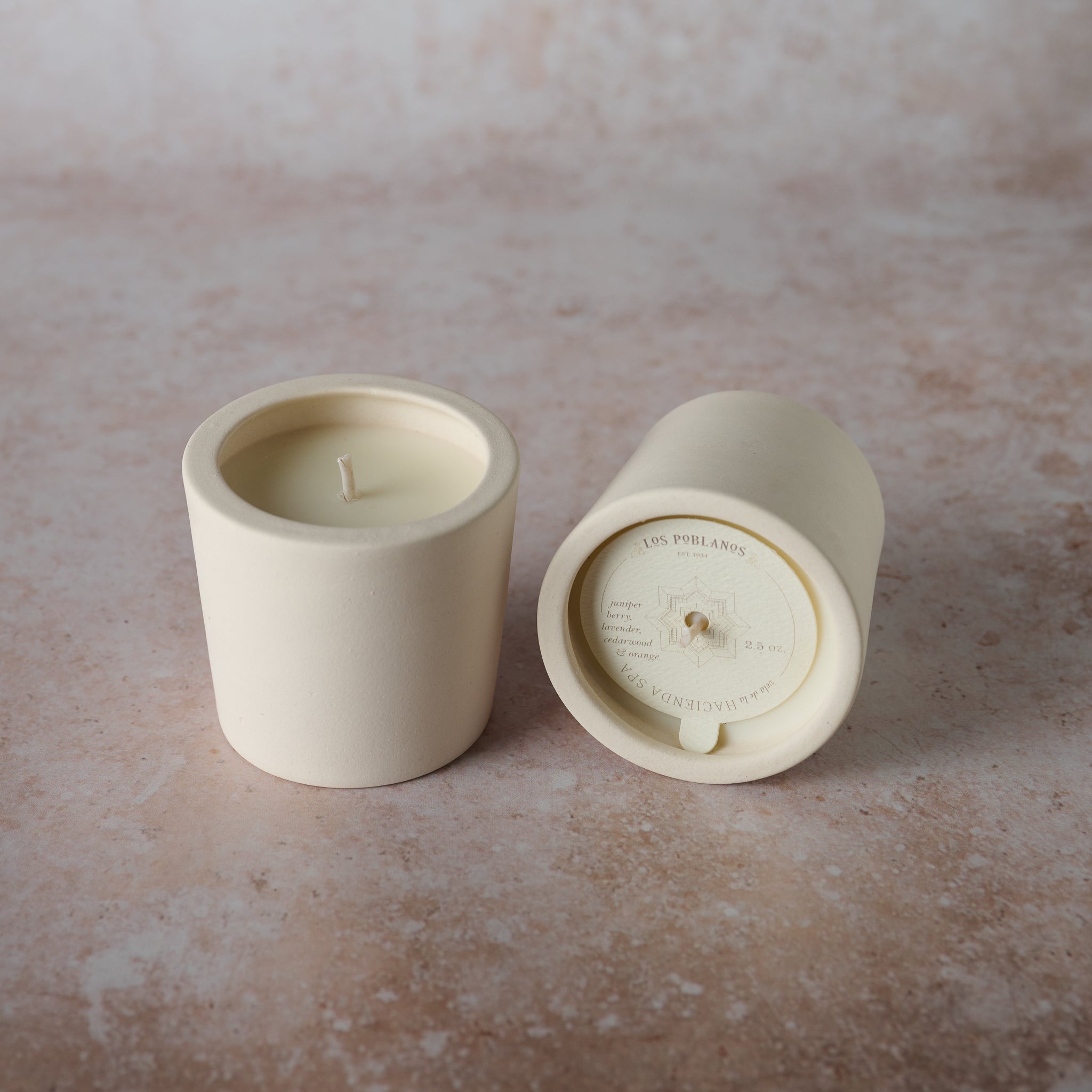 A soy wax candle with cedarwood and orange scent, presented in a white porcelain jar.