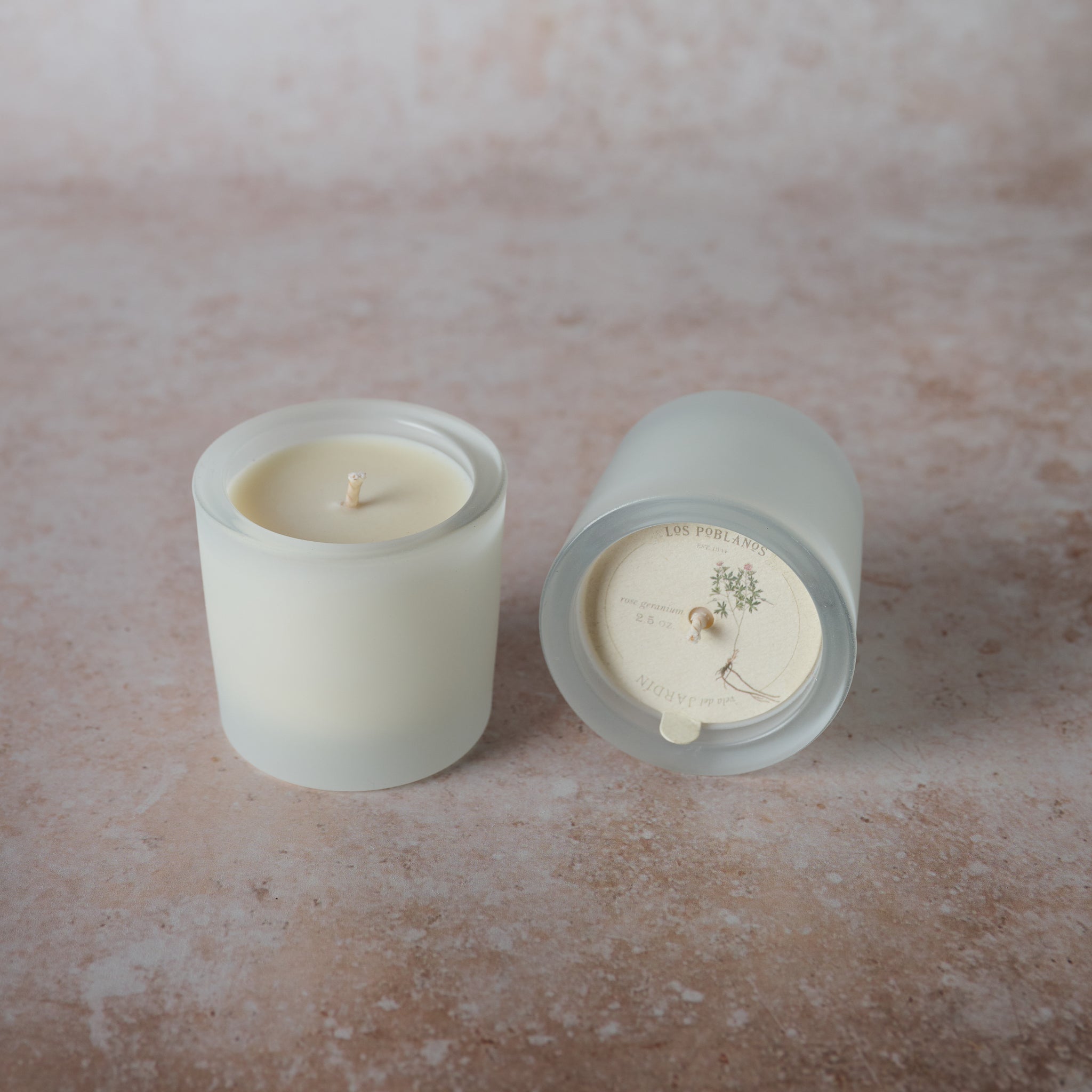 A frosted white glass candle jar. The candle is unscented and appears to be natural soy wax.