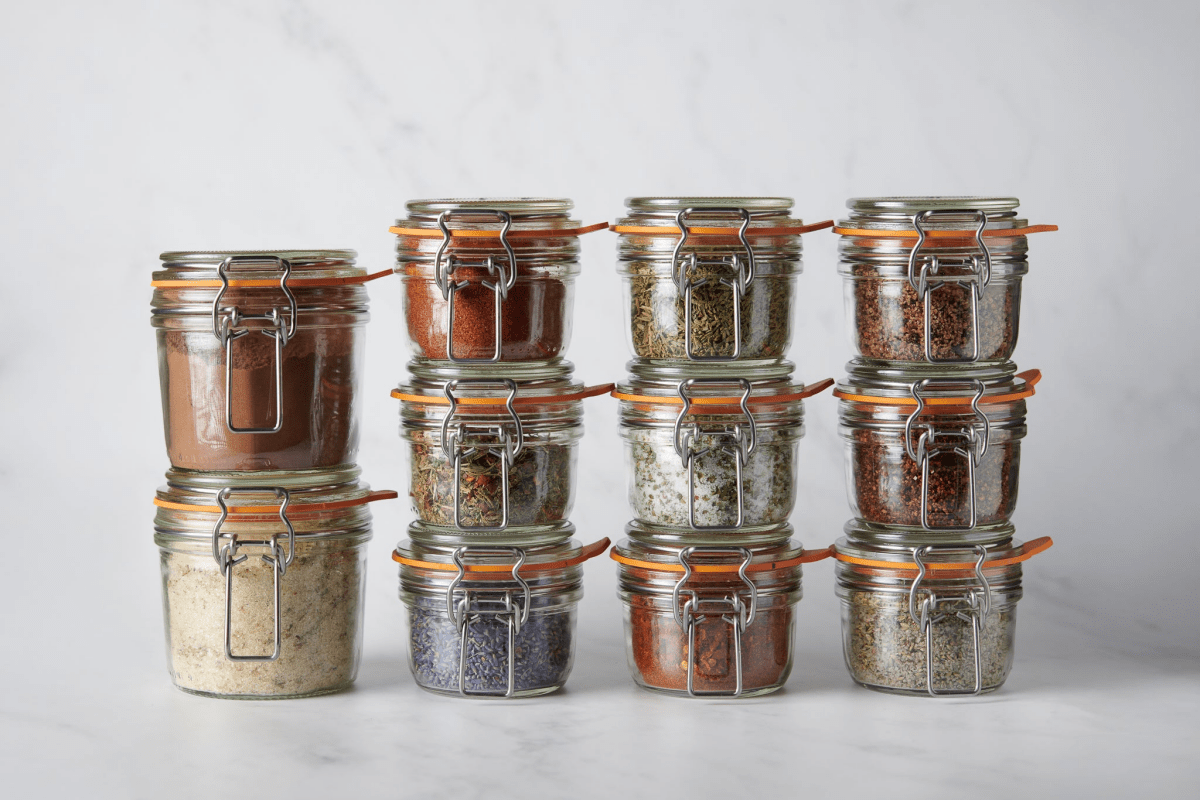 glass weck jars with herbs and salts on marble background