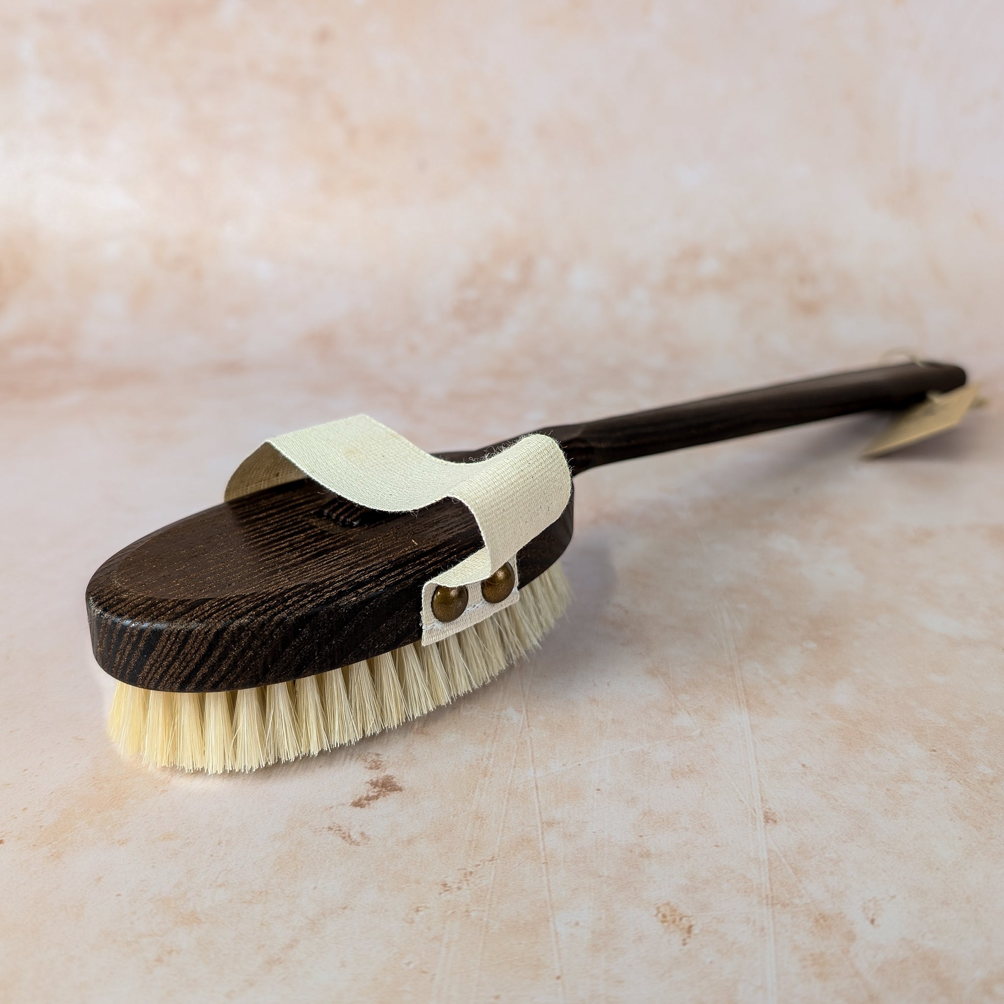 Wooden brush with bristles on a beige marble background