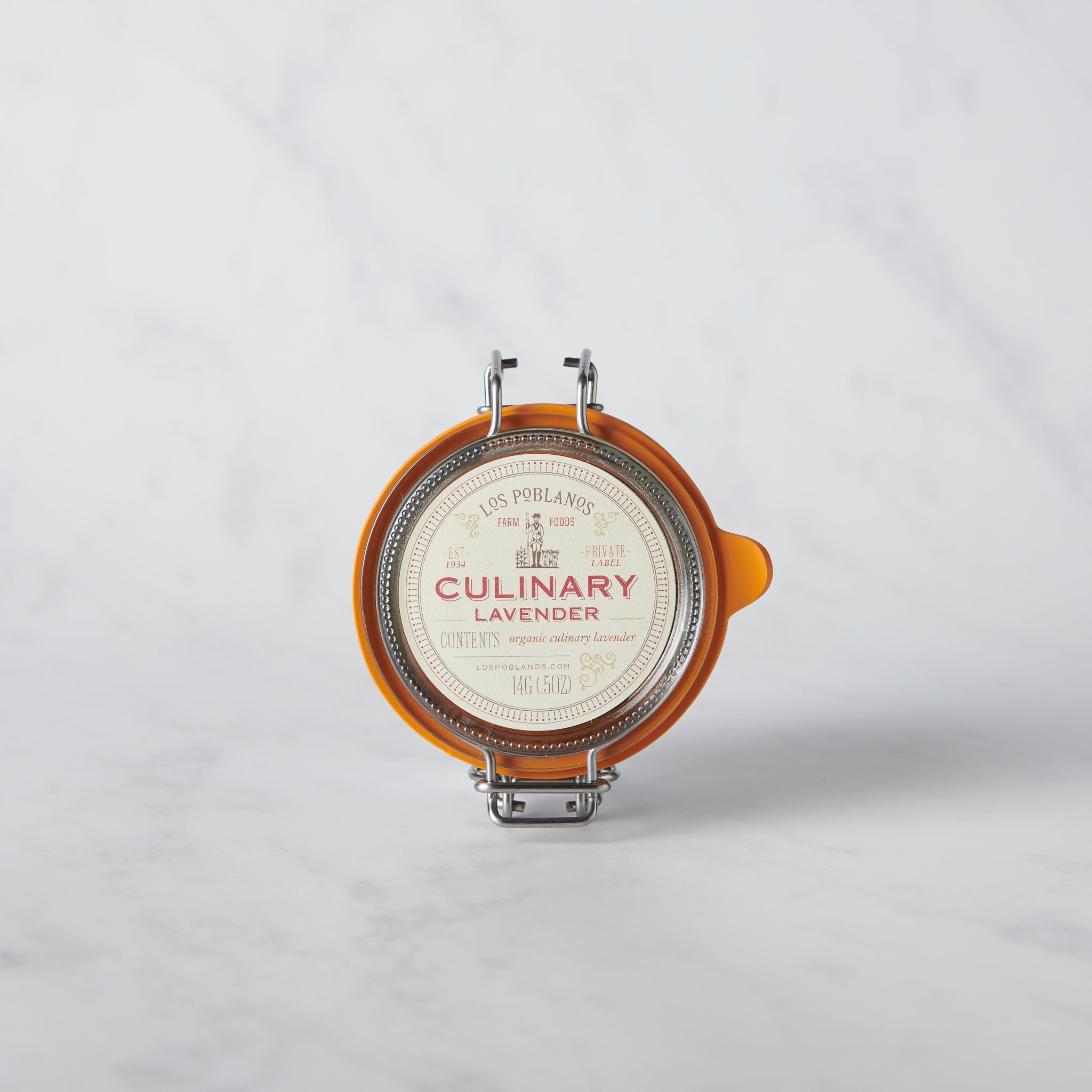 A glass jar with a metal clasp lid labeled 'CULINARY Lavender', containing culinary lavender buds.
