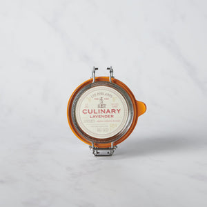 A glass jar with a metal clasp lid labeled 'CULINARY Lavender', containing culinary lavender buds.