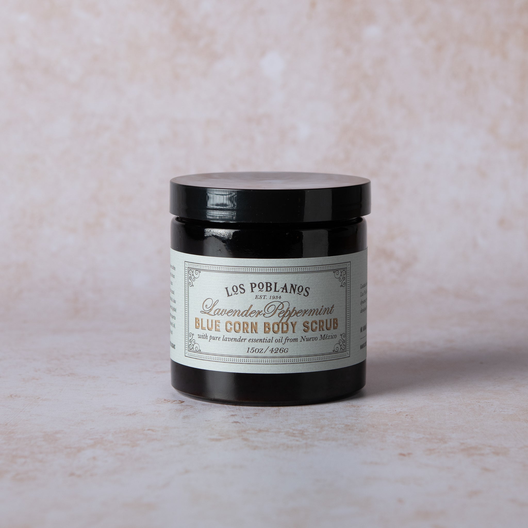Jar of Lavender Peppermint Blue Corn body scrub with white product label, raw sugar/salt texture and hints of blue corn—luxury spa exfoliant by Los Poblanos.