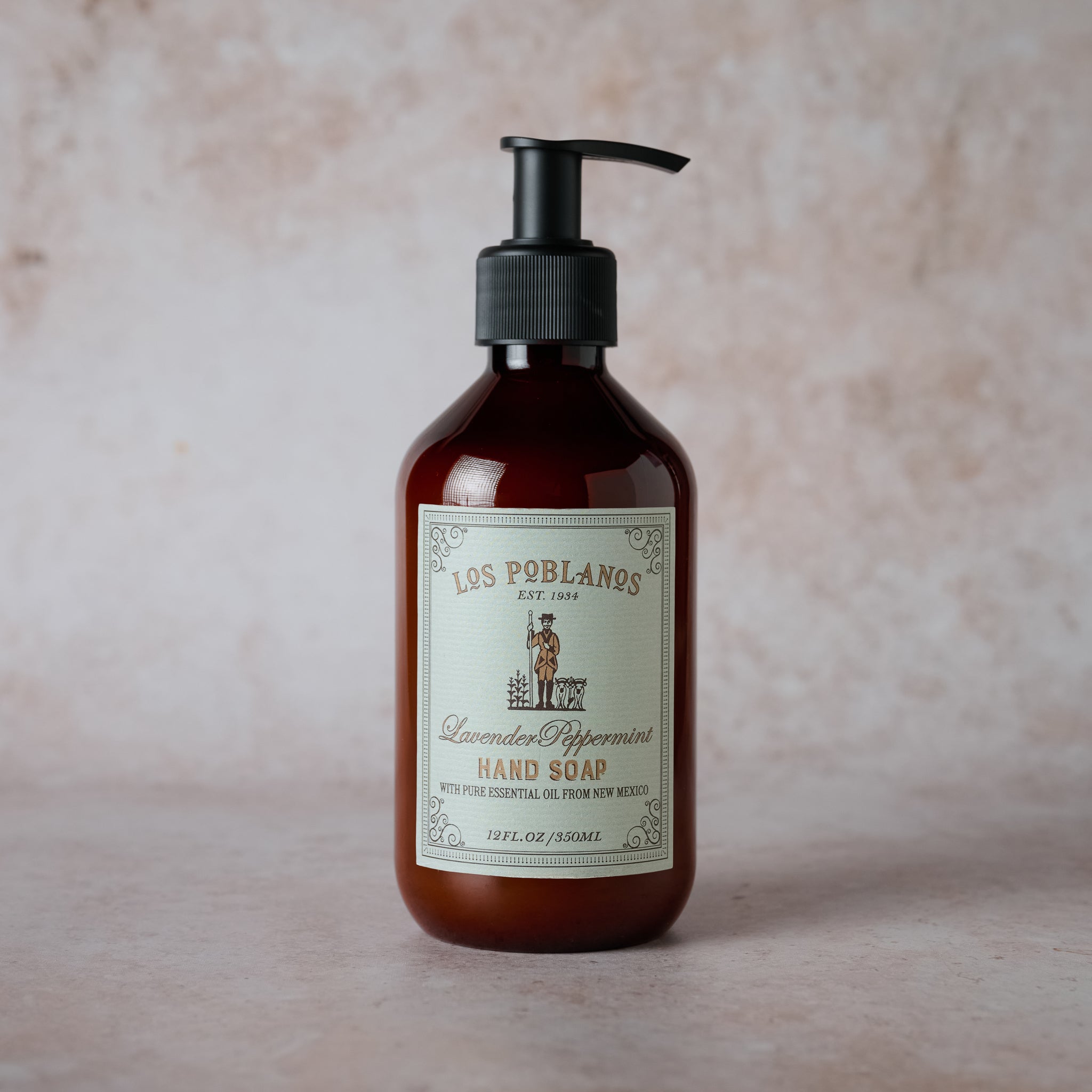 Brown bottle of Los Poblanos hand soap with a pump on a beige background