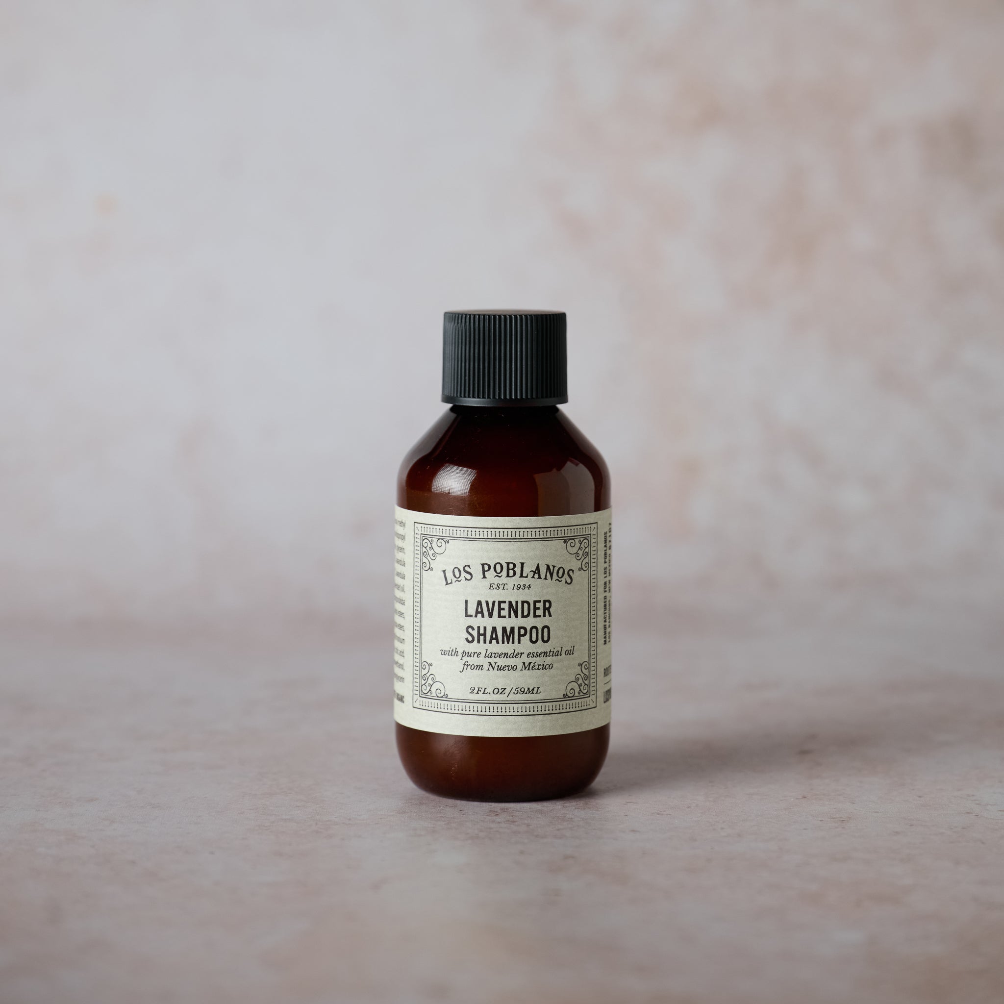 A small bottle of Los Poblanos Lavender Shampoo with a label that includes the brand name and the words 'Lavender Shampoo with organic lavender essential oil from New Mexico'.