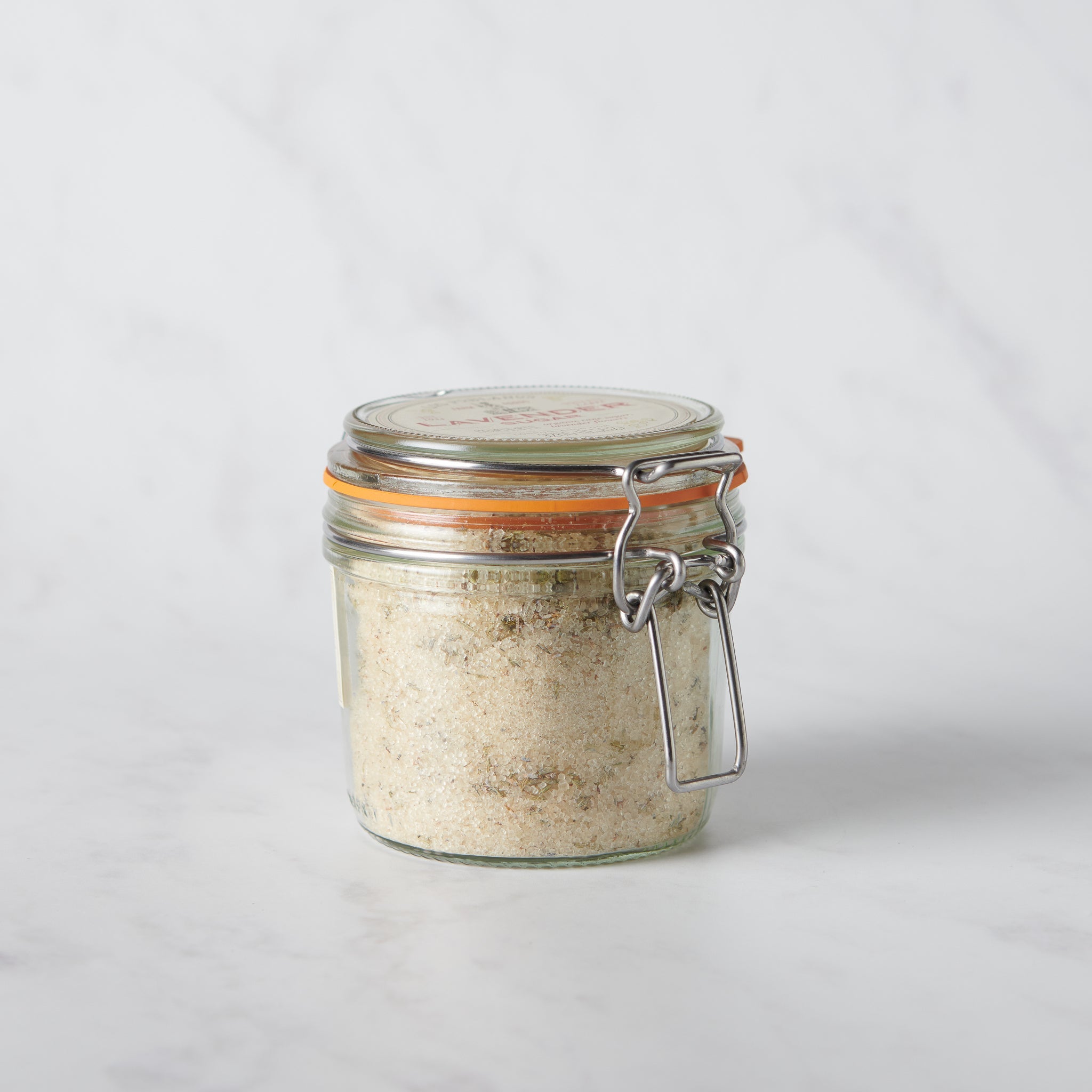 Glass jar with a metal clasp on a light gray background