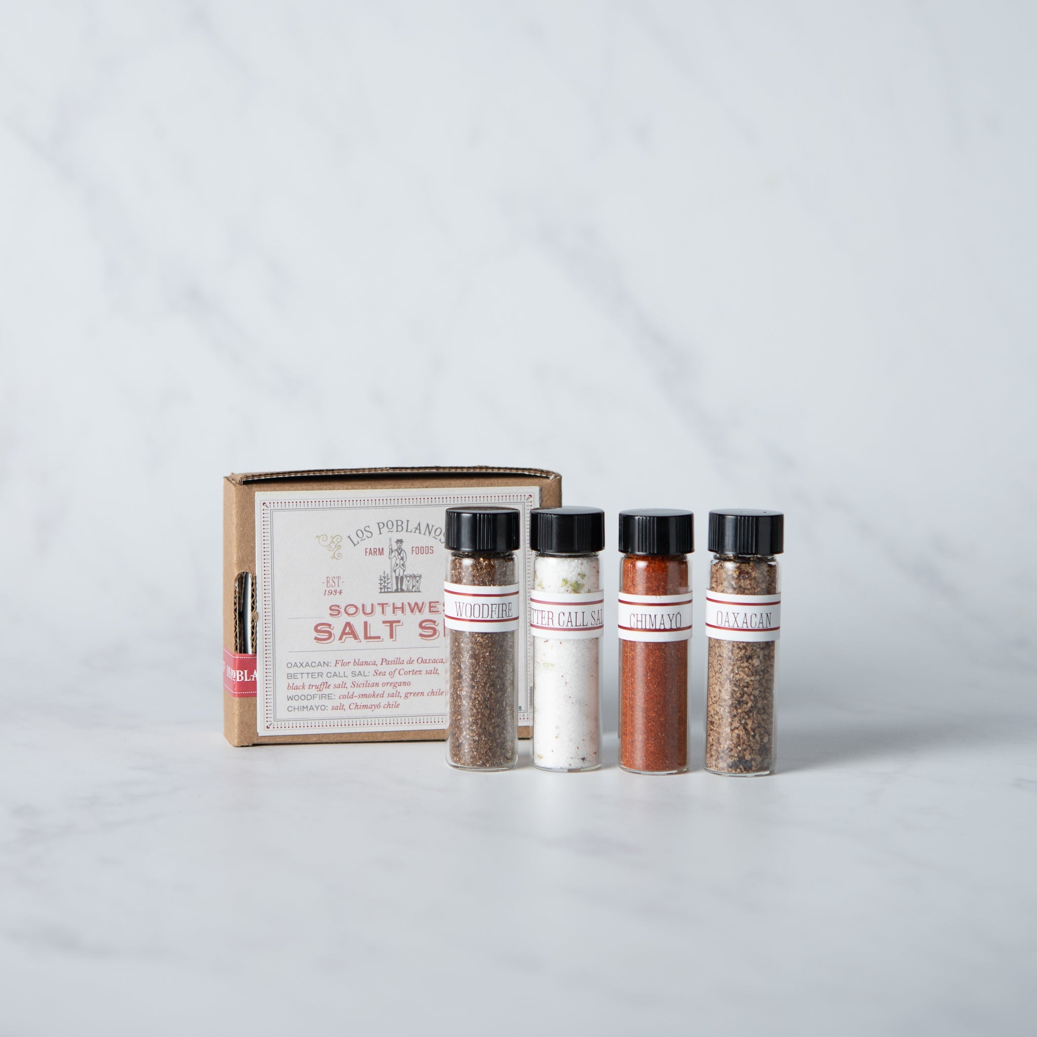 Set of spice bottles with a wooden box on a light gray background