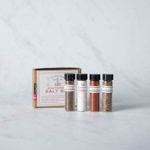 Set of spice bottles with a wooden box on a light gray background