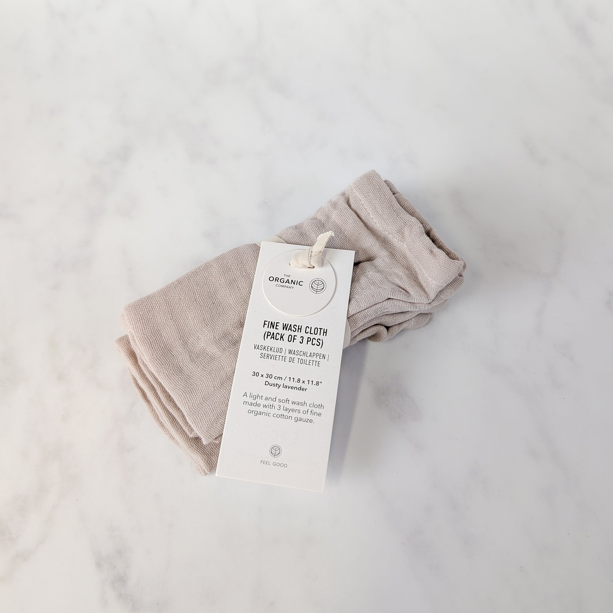 Folded organic wash cloth with a tag on a light gray background