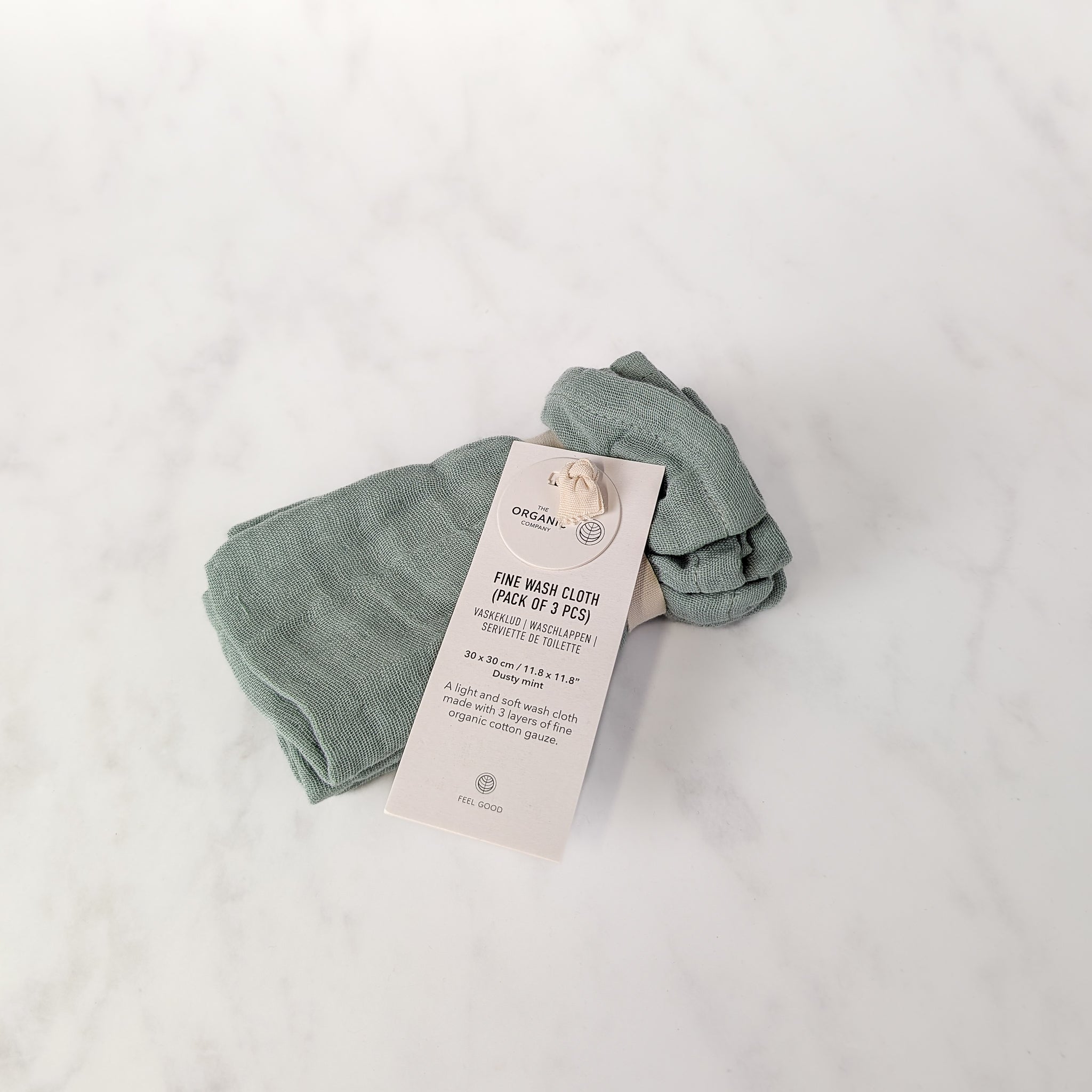 Folded organic wash cloth with a tag on a light gray background